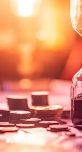 Hourglass with coins representing time-sensitive 1031 exchange and sale-leaseback real estate investment strategies