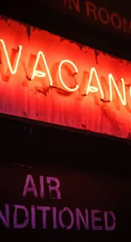 An illuminated neon "vacancy" sign.