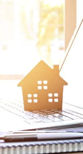 Wood house model on computer laptop