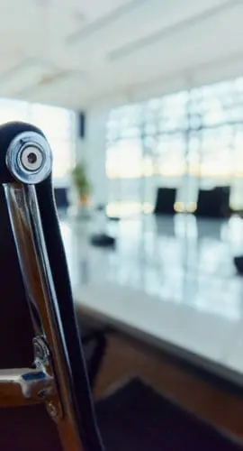 Close up of a black office chair with metal details at conference table in meeting room.