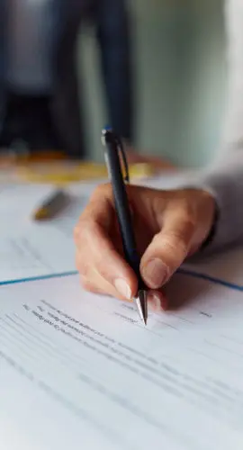 Close up of unrecognizable woman signing a contract.