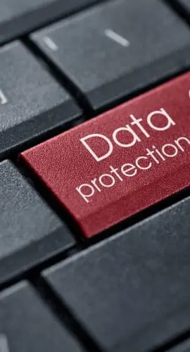 A close-up of a keyboard with a red key featuring a lock icon and the words "Data protection."