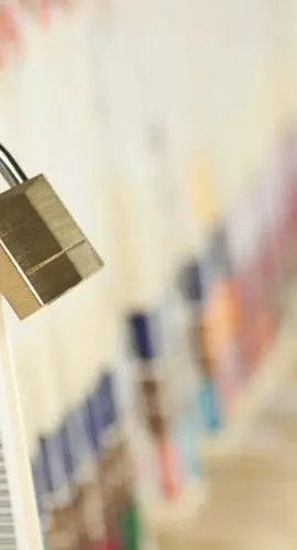 A padlock secures locker number 10 in a corridor lined with lockers.