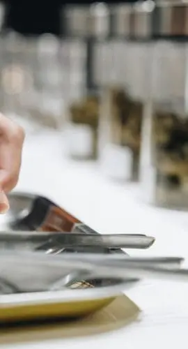 Owner preparing cannabis buds products for grinding using marijuana grinder on the table at cannabis shop.