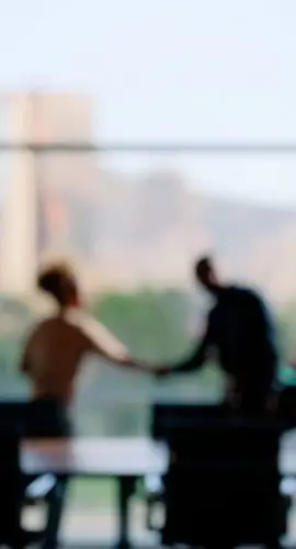 Blurred image of people in a business setting. shaking hands. Family Office Services