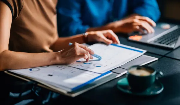 Handshake over commercial real estate loan documents, illustrating special purpose entity (SPE) carveouts and non-recourse loan terms for lenders and borrowers.