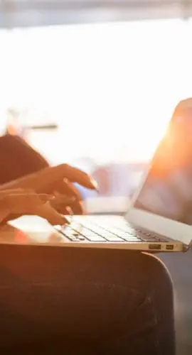 Unrecognizable young woman uses laptop while waiting for an early morning flight.